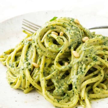 Close-up of one creamy pasta recipes that combines spaghetti with pesto and cheese.