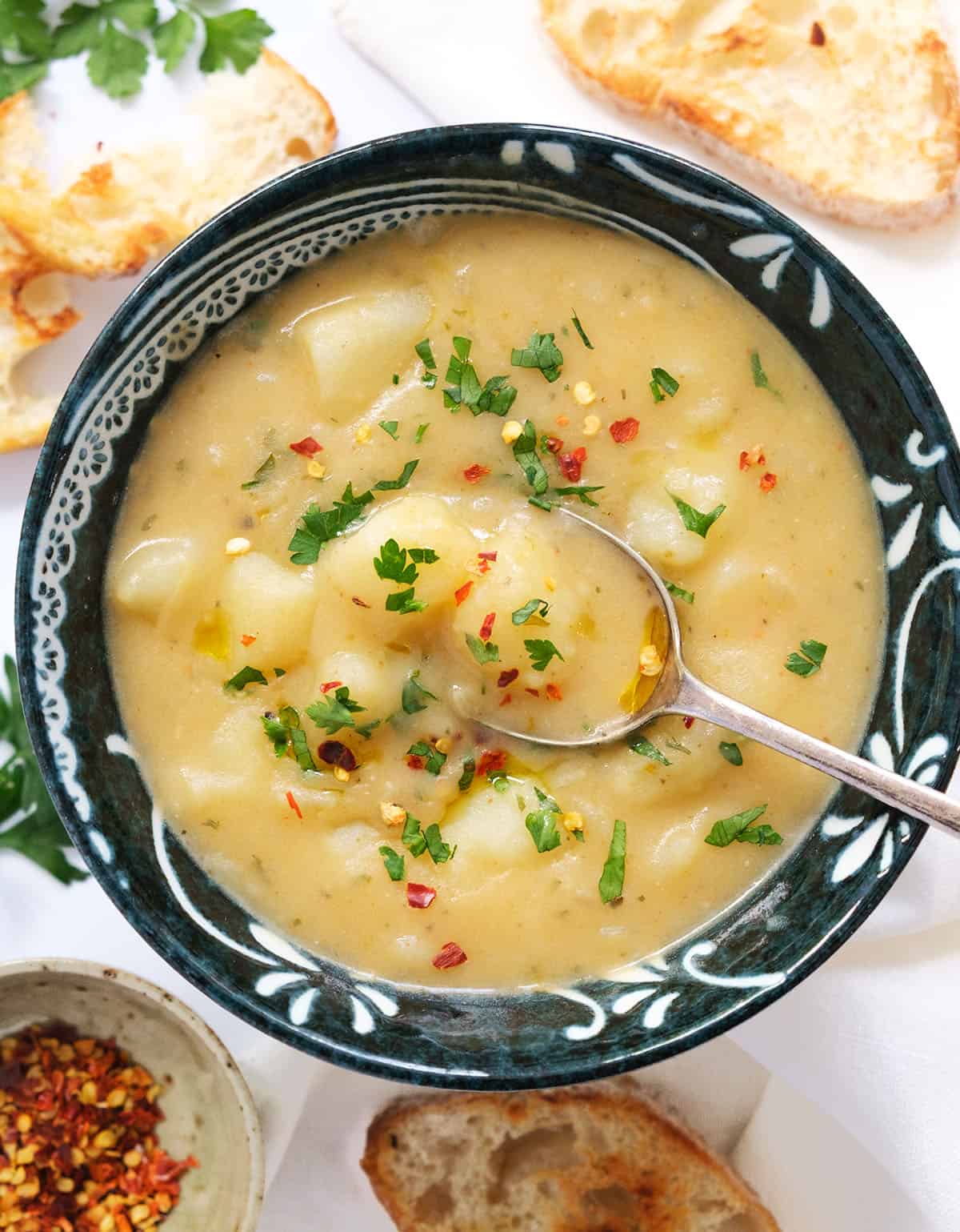 Top view of a black bowl full of vegan potato soup.