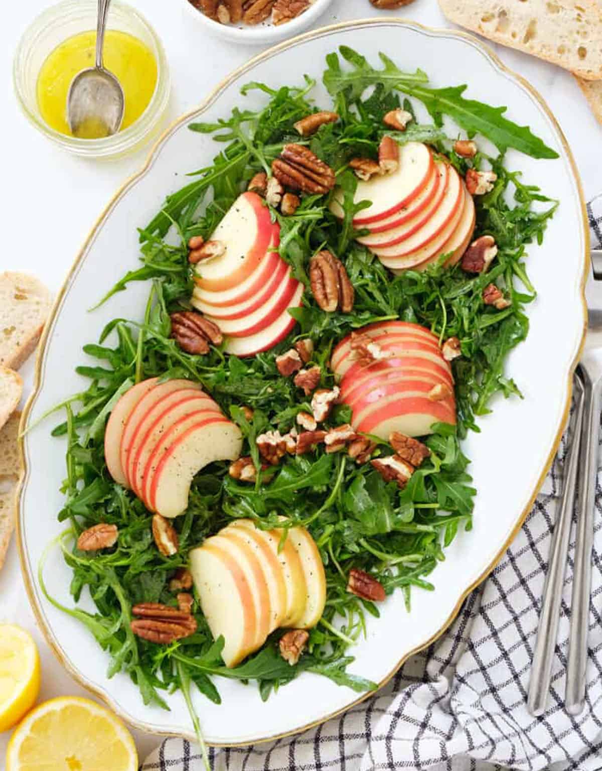 Top view of a large serving plate full of arugula apple salad.