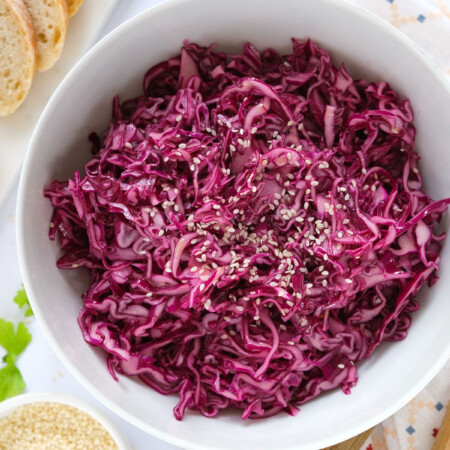 Tip view of a white bowl full of red cabbage salad.