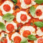 Ricotta pizza topped with cherry tomatoes and basil.