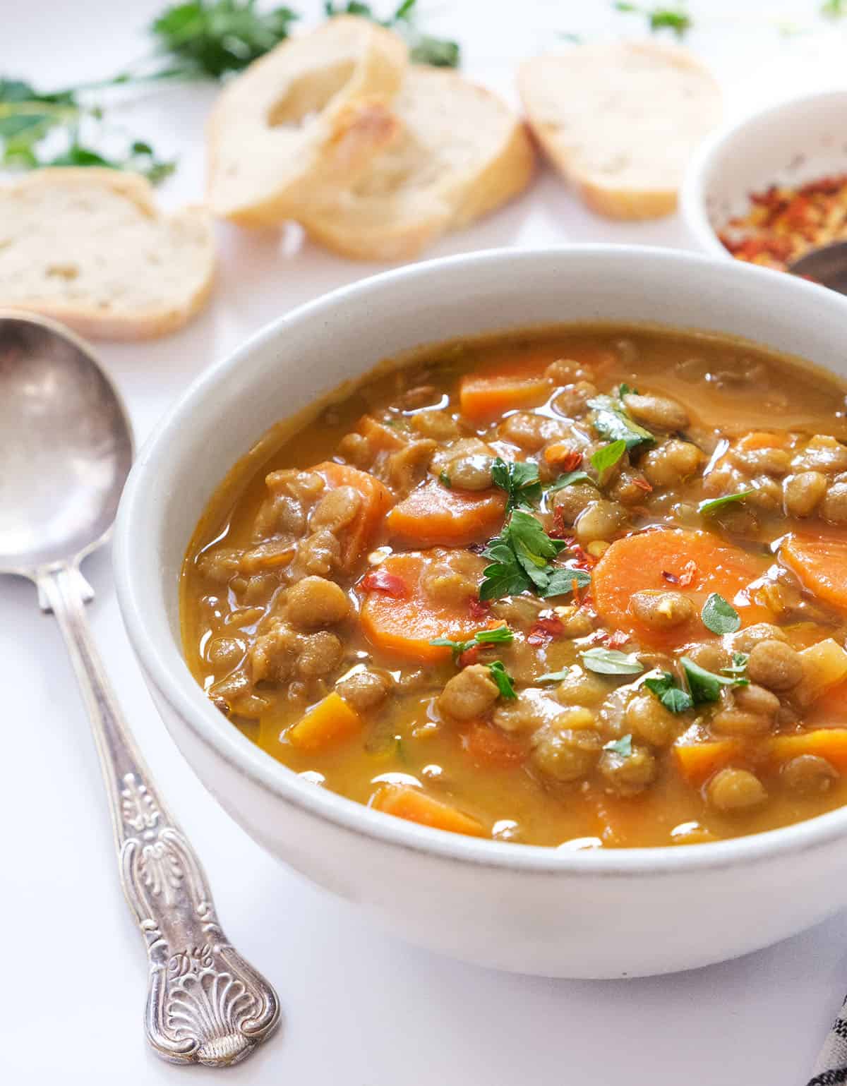 Close-up of a white bowl full of carrot lentil soup.