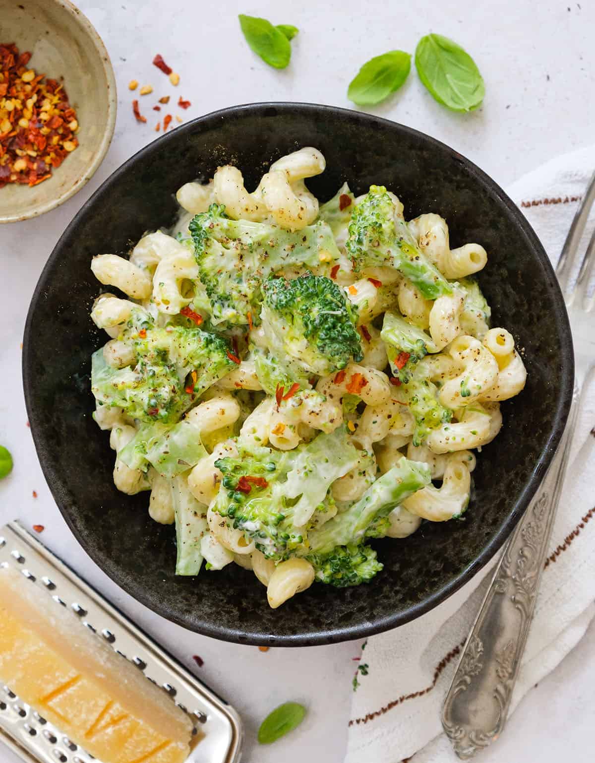 Top view of a black bowl full of creamy broccoli pasta.