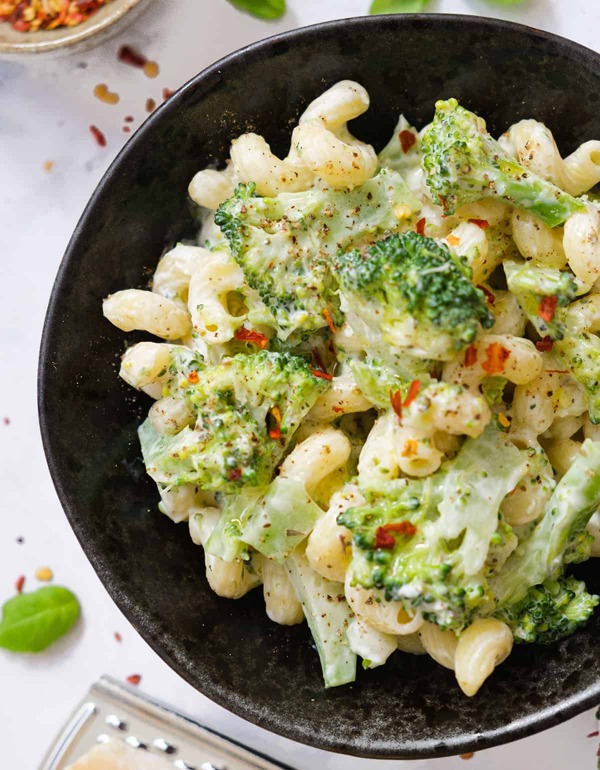 Close-up of a black bowl full of creamy broccoli pasta.