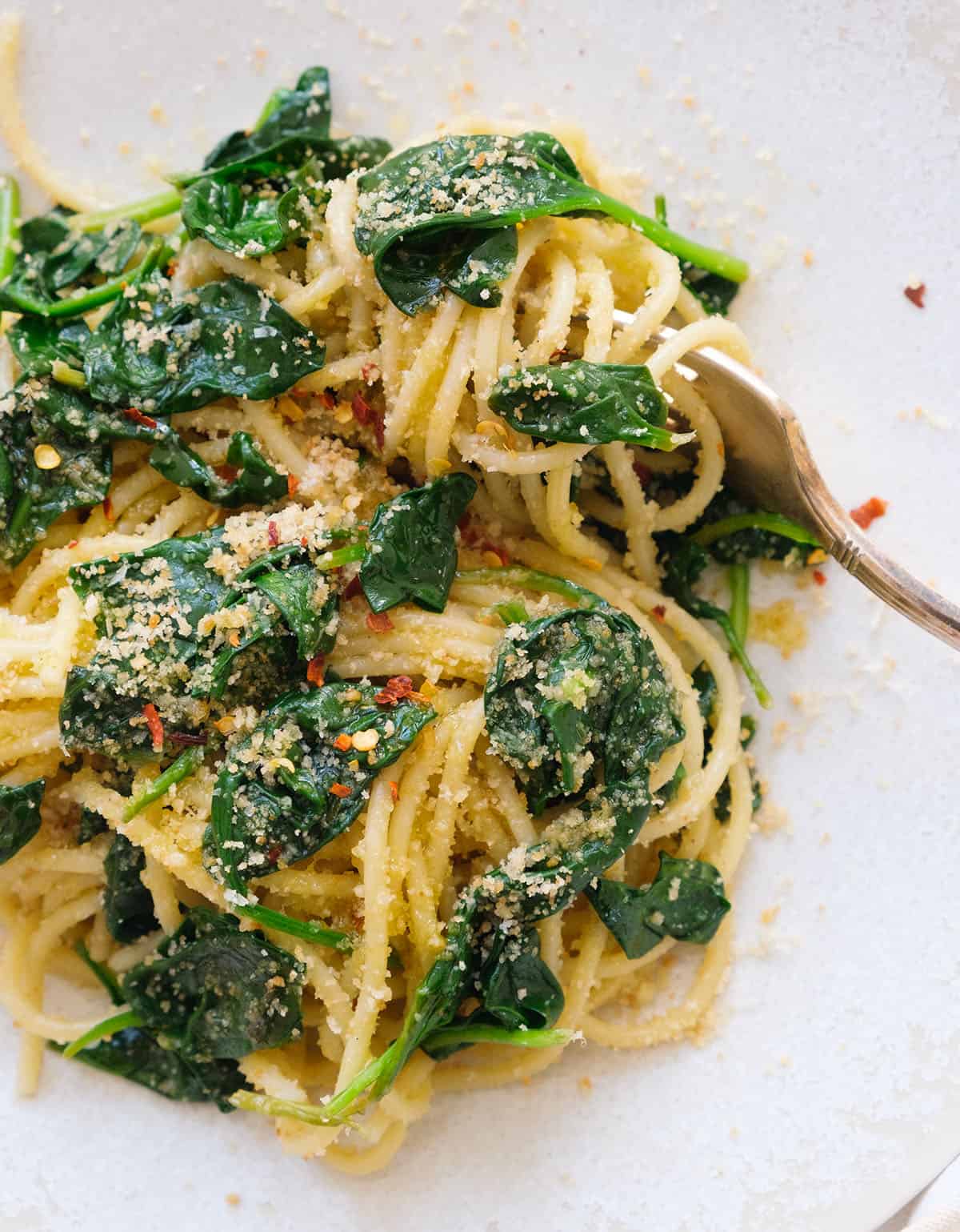 Close-up of some spinach spaghetti with delicious crumbs.