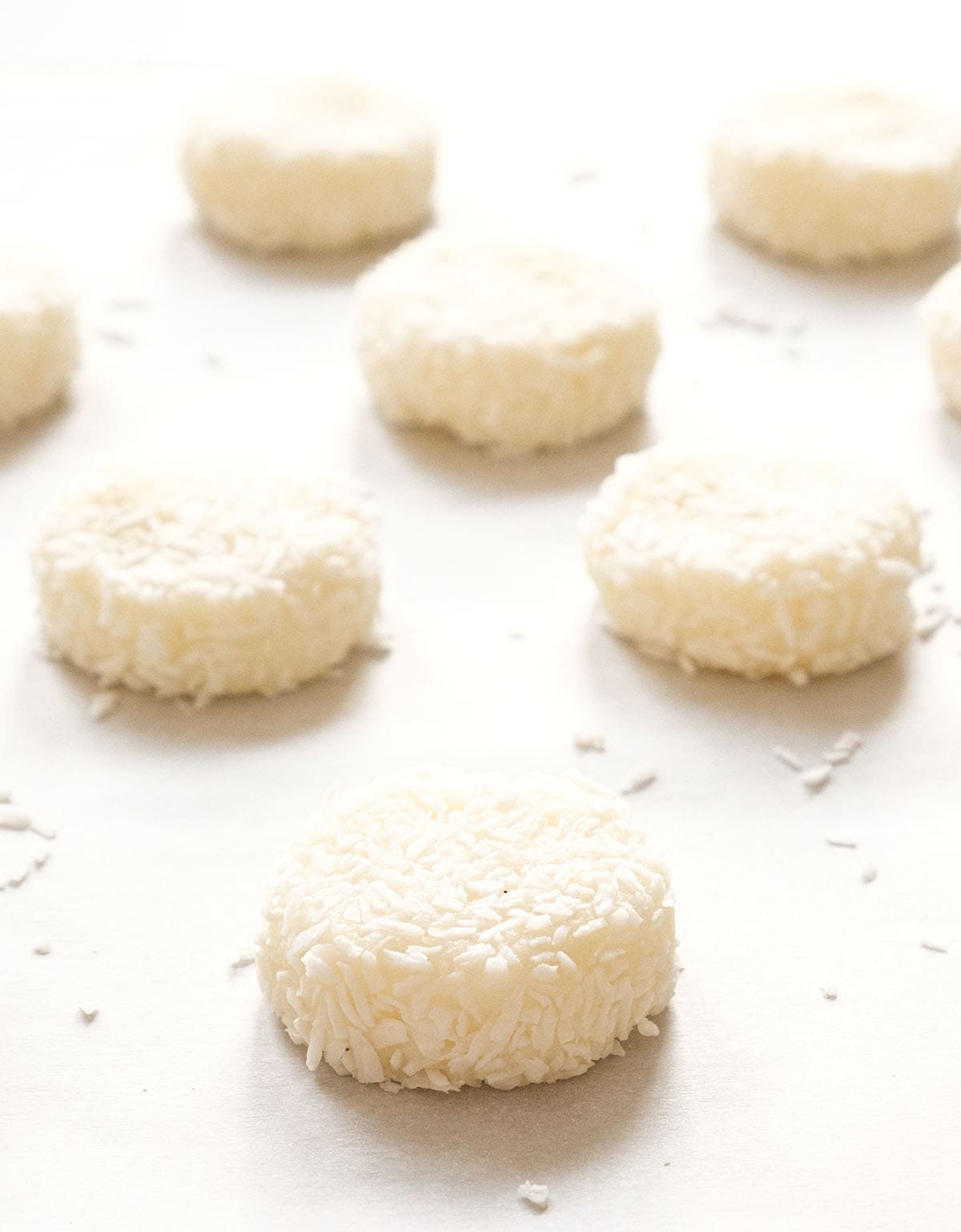 Close-up of a few coconut cookies on a baking sheet before baking.