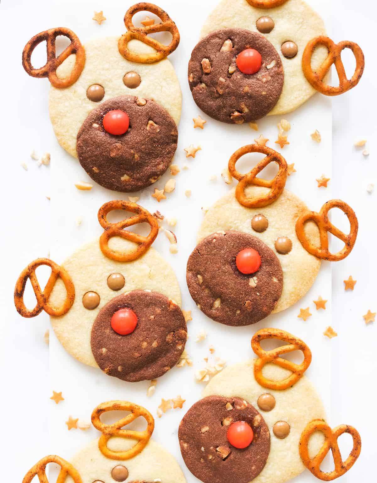 Top view of a few reindeer cookies over a white background.