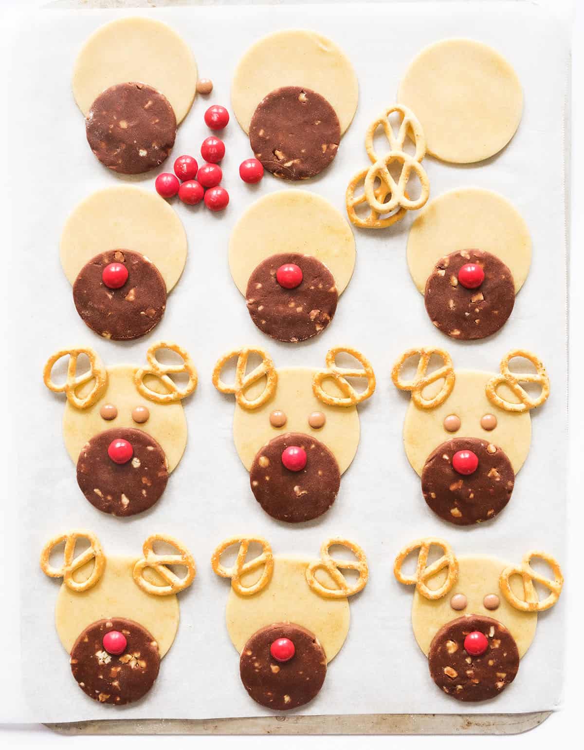 Top view of a baking sheet showing how to assemble the reindeer cookies.