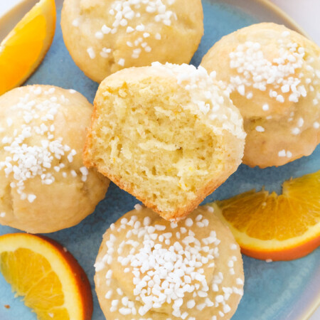 Top view of a few orange muffins over a light blue plate.