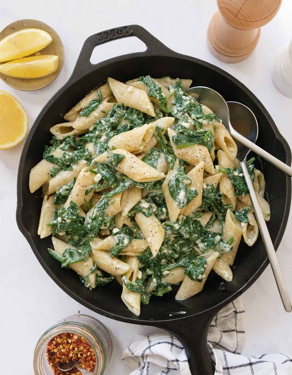 Top view of a cast iron skillet full of spinach feta pasta.