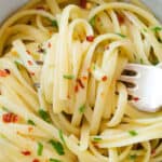 Close-up of a white bowl full of garlic butter pasta.