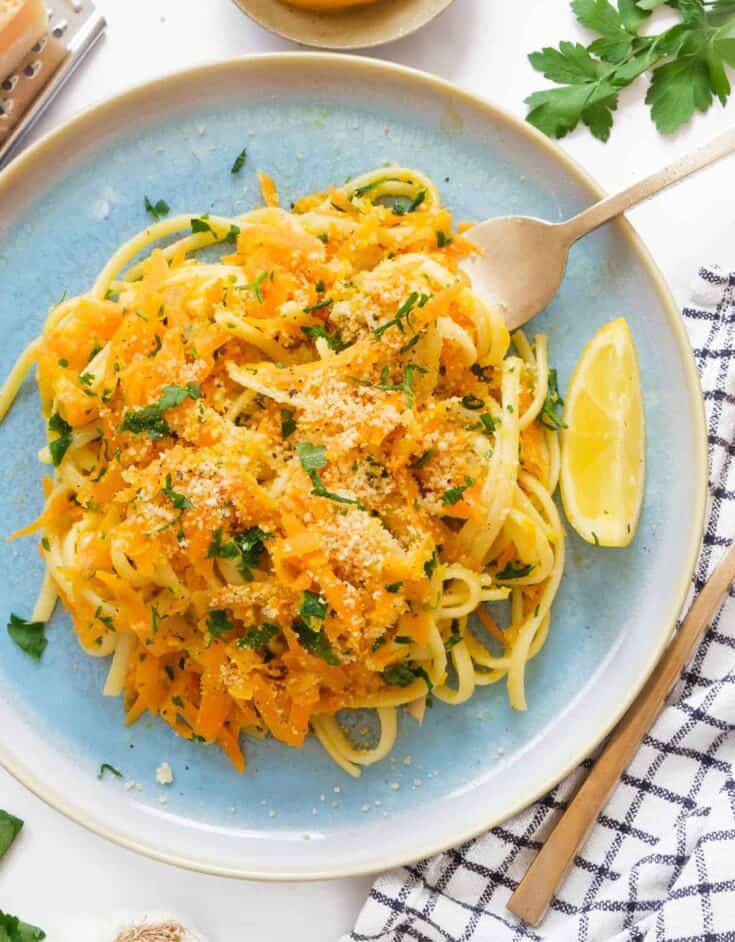Top view of a turquoise plate full of carrot pasta.