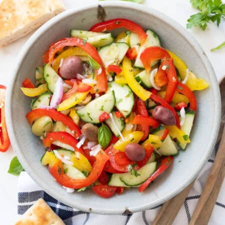 Peppers cucumber salad in a grey bowl.