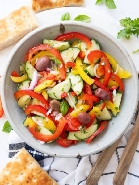 Peppers cucumber salad in a grey bowl.