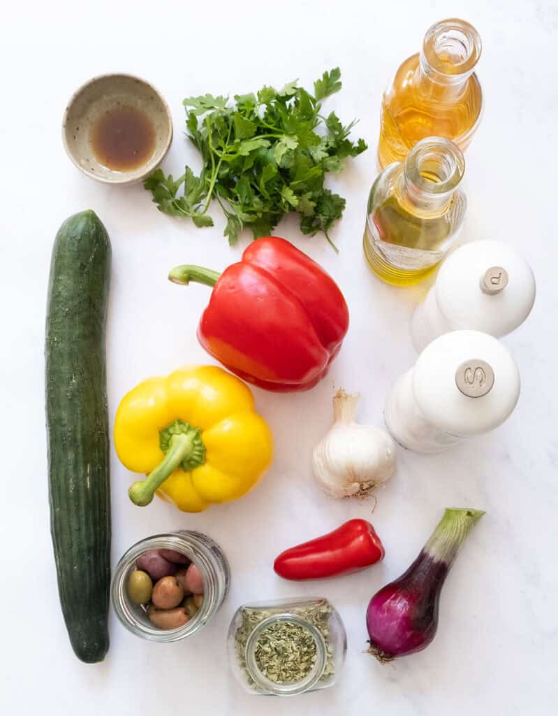 The ingredients to make pepper cucumber salad are arranged over a white background.