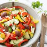 Pepper cucumber salad in a grey bowl.