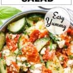 Top view of a salad bowl full of sun-dried tomato salad with cucumber.