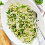 Top view of a serving dish full of fava bean salad with pecorino cheese and fennel.