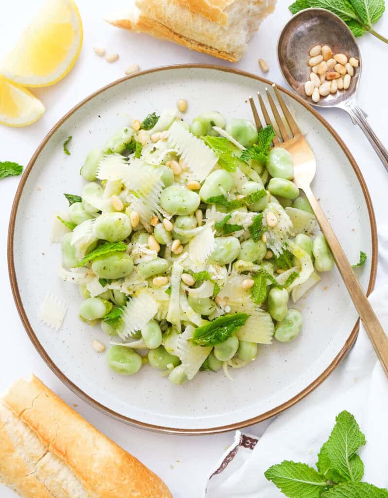 Top view of a round plate full of fava bean salad.