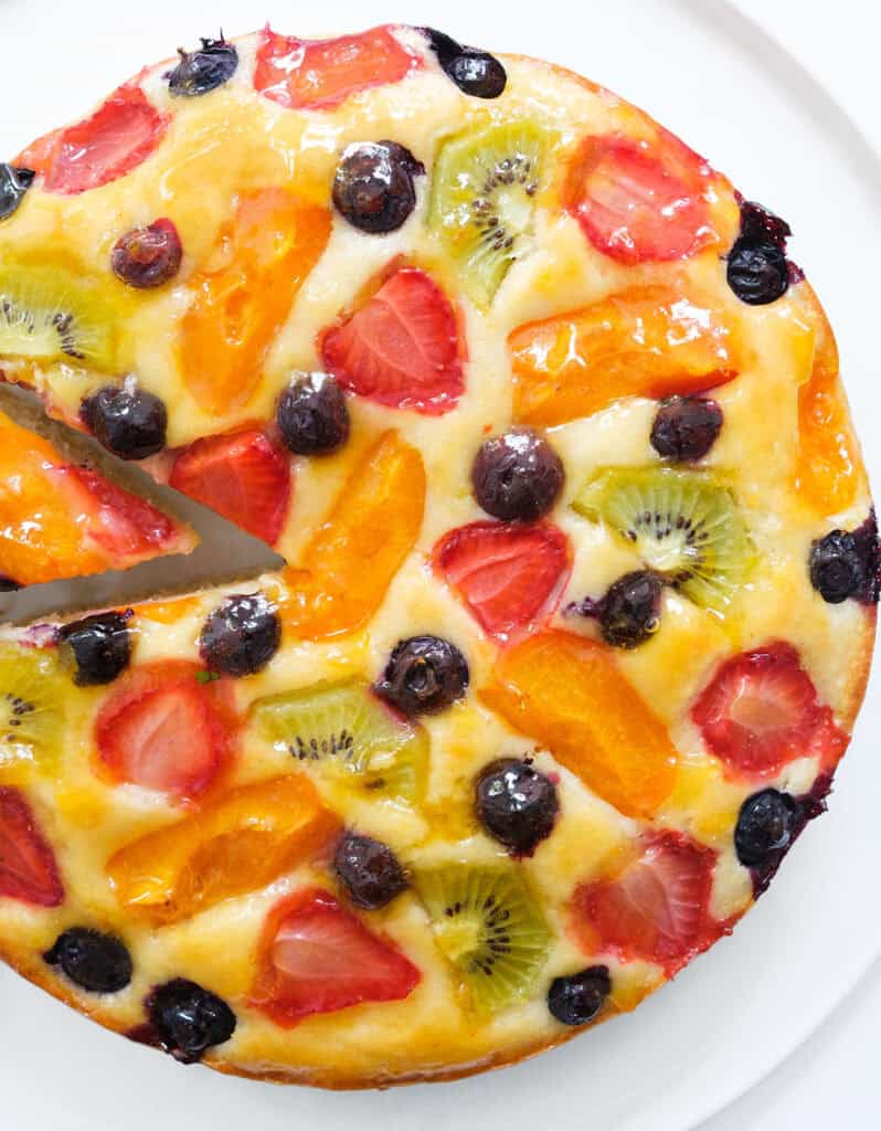 Top view of a juicy fruit cake over a white background.