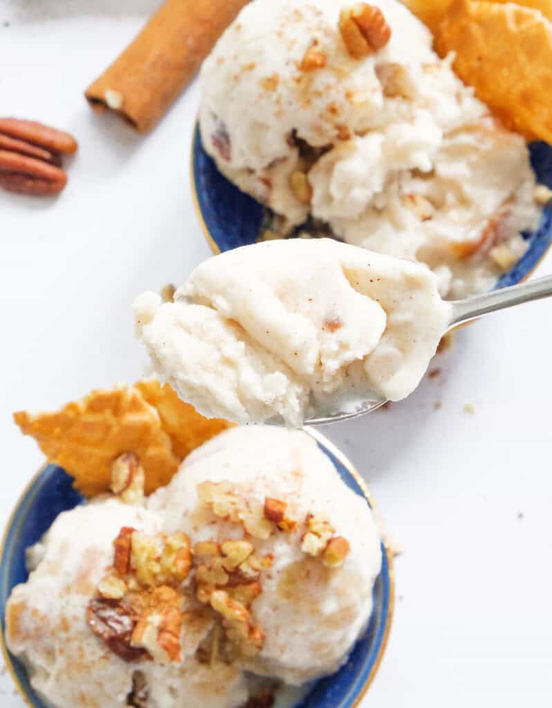 Close-up of a spoon full of apple ice cream serve with waffle cones.