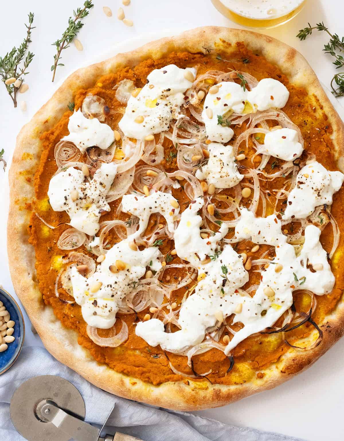 Top view of a pumpkin pizza topped with creamy burrata cheese.