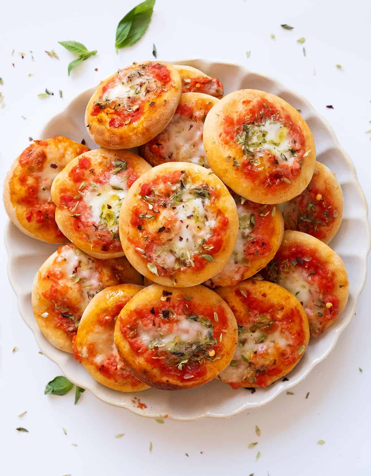 Top view of a plate full of mini pizzas.
