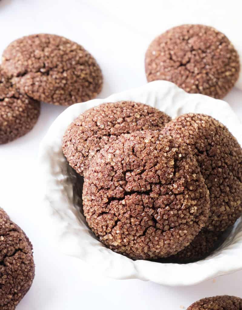 Close-up of cocoa cookies in a white bowl over a white background.