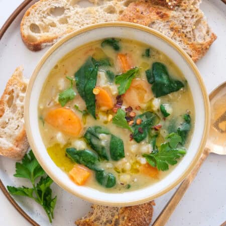 Top view of a bowl full of vegan barley soup with vegetables.