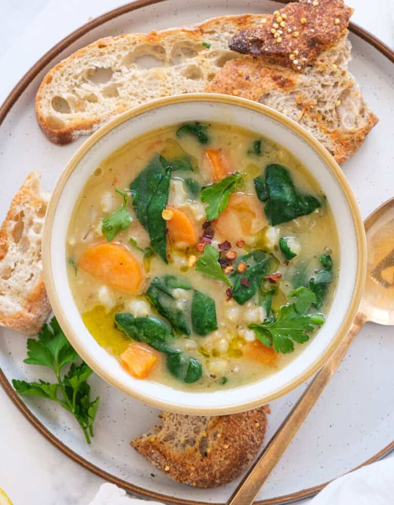 Top view of a bowl full of vegan barley soup with vegetables.