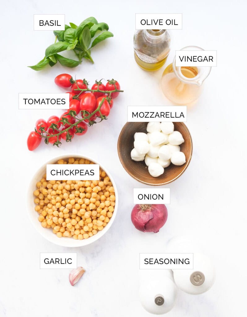 Top view of the ingredients to make this Italian chickpea salad are arranged over a white background.