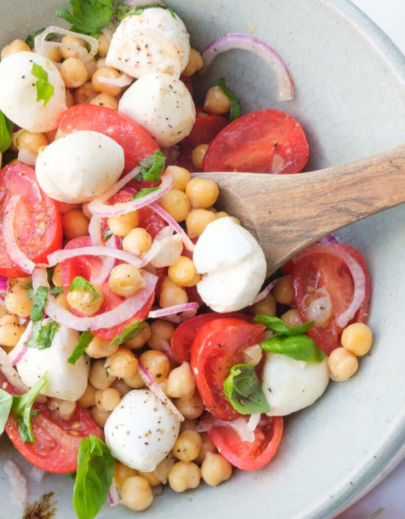 Close-up of some Italian chickpea salad with tomatoes, mozzarella and basil.