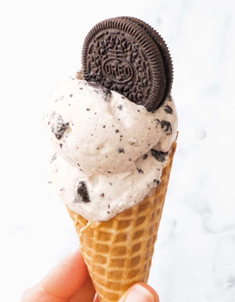 An oreo ice cream cone topped with an oreo cookie.