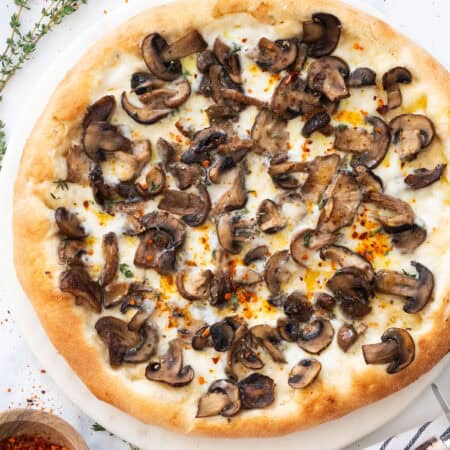 Top view of a mushroom pizza over a white background.