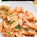 Tomato and ricotta pasta on a white plate.