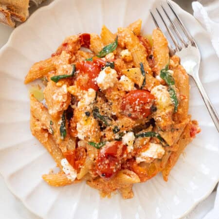 Tomato and ricotta pasta on a white plate.