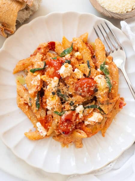 Tomato and ricotta pasta on a white plate.