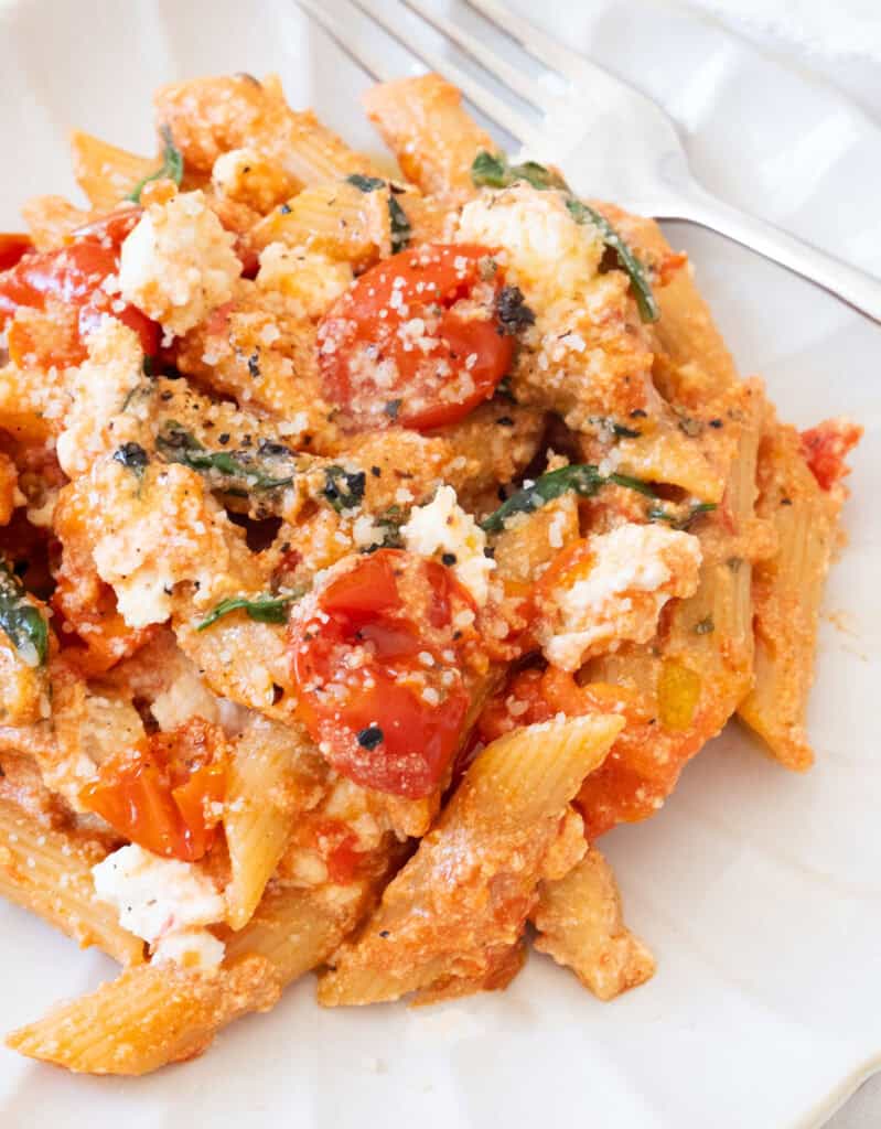 Close-up os fome tomato ricotta pasta on a white plate.