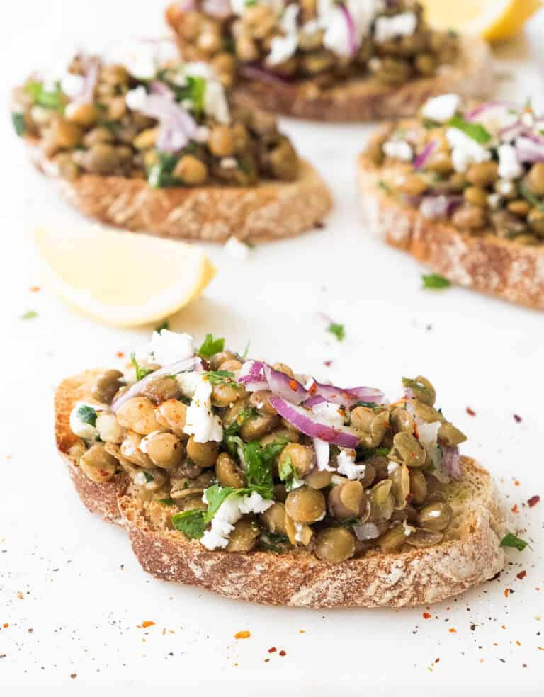 Lentil bruschetta on a white background.