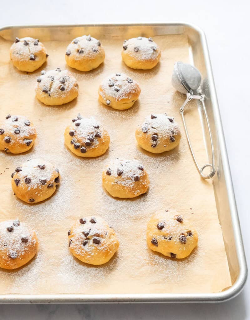 Freshly baked chocolate chip ricotta cookies on a baking sheet.