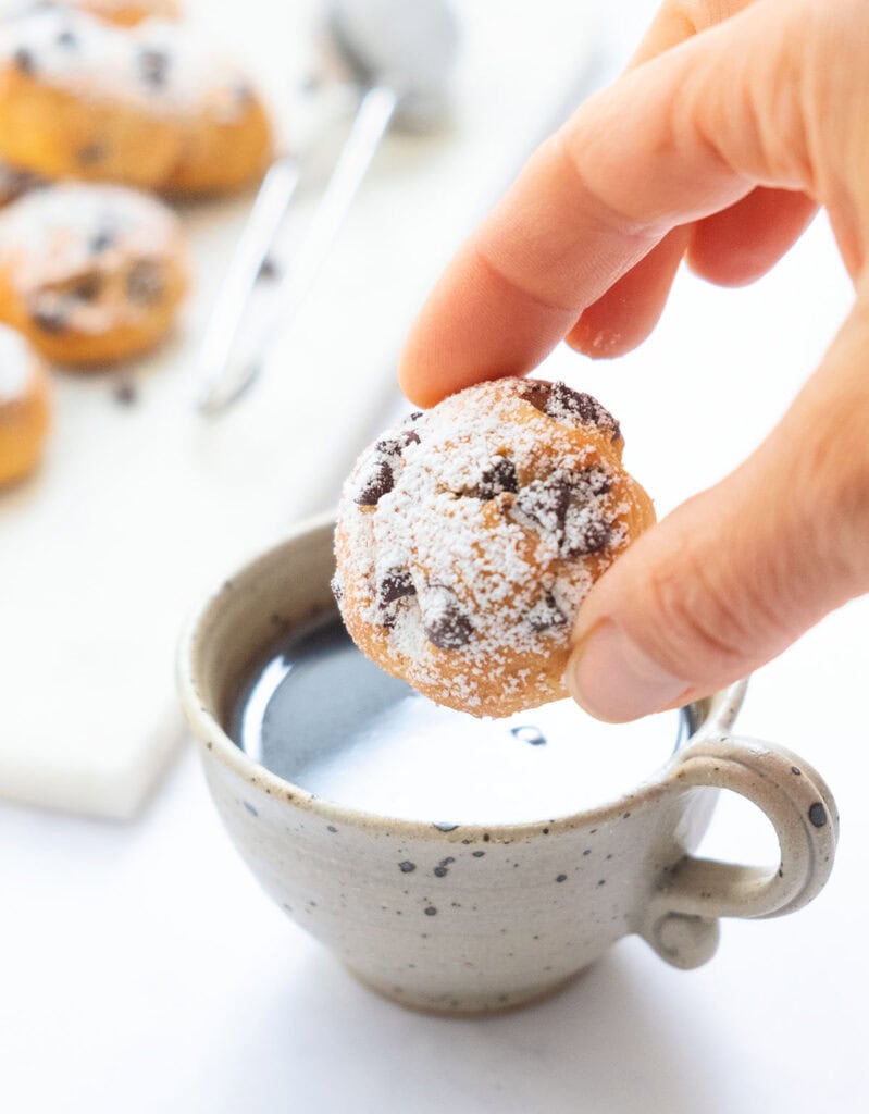 A ricotta chocolate chip cookie dipped into a cup of coffee.