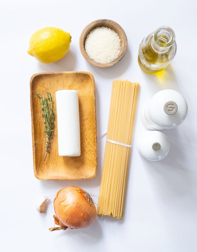The ingredients to make goat cheese pasta are arranged over a white background.